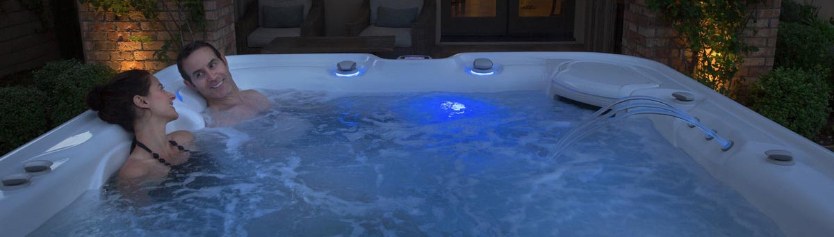 Couple relaxing in a Hot Spring Hot Tub at night - complete relaxation and cofidence