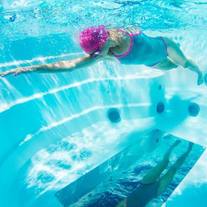 Woman swimming with a mirror below her