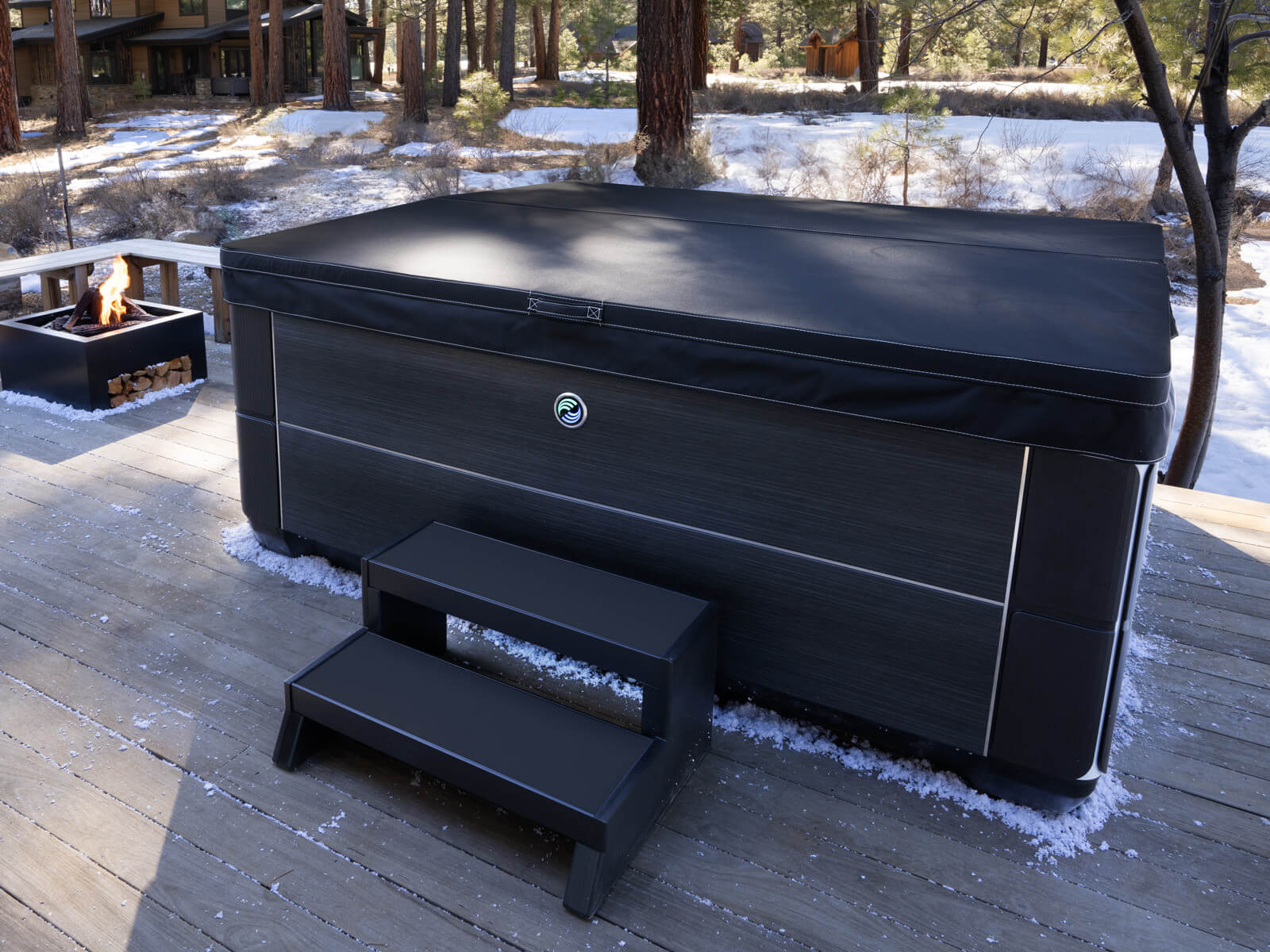 Hot tub with dover on a deck in a snowy backyard