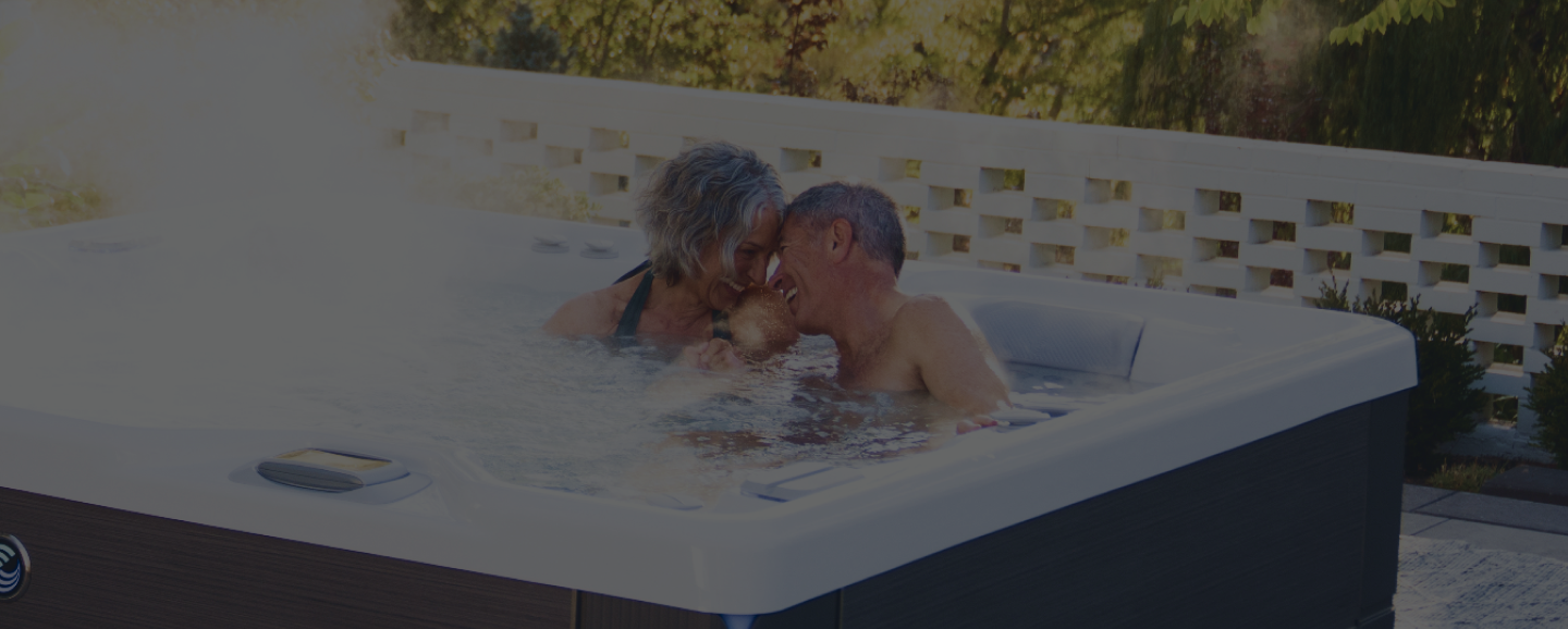 Older couple laughing together in a hot tub